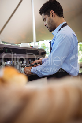 Waiter making cup of coffee from espresso machine