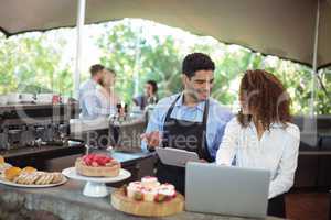 Male waiter and female waitress with laptop