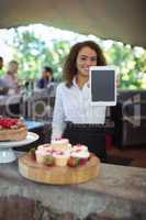 Waitress showing digital tablet at outdoor cafÃ?Â©
