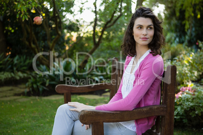 Thoughtful woman sitting on park bench