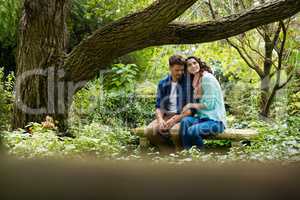 Romantic couple sitting on bench in garden