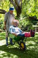 Senior man giving woman ride in wheelbarrow