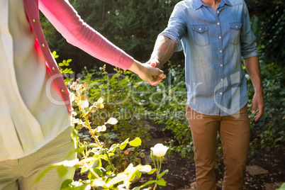 Mid-section of couple holding hands