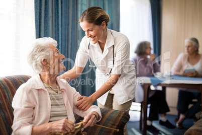 Smiling female doctor talking with senior woman