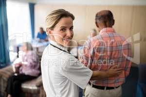 Portrait of smiling female doctor standing with senior man