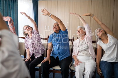 Smiling senior people stretching with female doctor