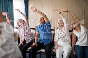 Smiling senior people stretching with female doctor