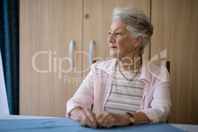 Thoughtful senior woman sitting at table