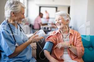 Smiling senior woman talking to female doctor