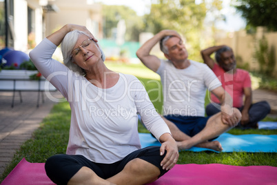 Senior people stretching heads while exercising