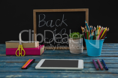 Text on slate with school supplies on tablet