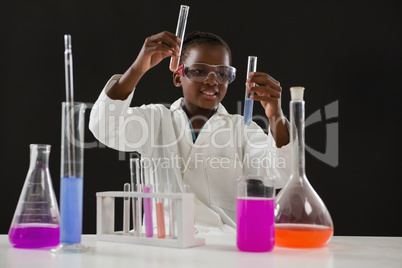 Schoolgirl doing a chemical experiment against black background