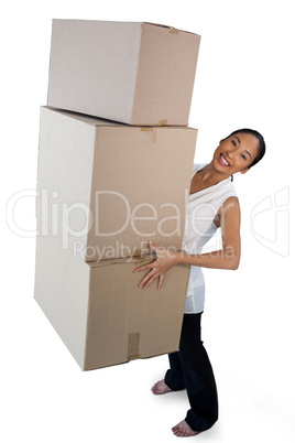 Portrait of smiling businesswoman carrying stack of cardboard boxes