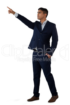 Confident businessman with hands in pockets touching invisible interface