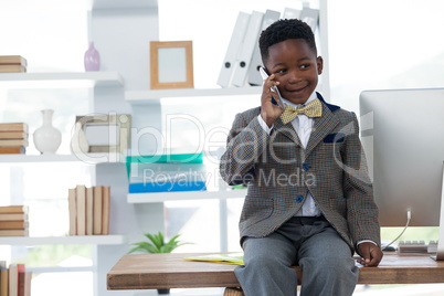 Boy imitating as businessman talking on smart phone