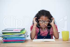 Businesswoman reading book while sitting at desk