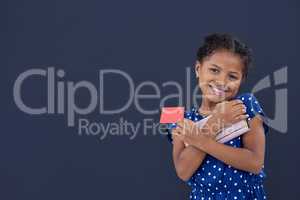 Portrait of smiling girl holding credit card while holding purse