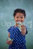 Portrait of happy girl giving currency