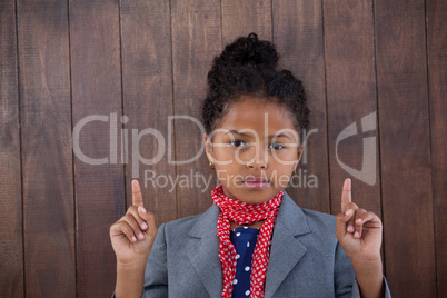 Portrait of girl pretending as businesswoman pointing upwards