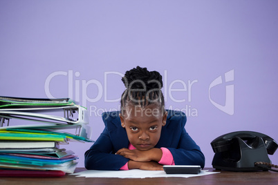 Portrait of bored businesswoman leaning by files and telephone