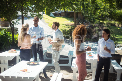 Friends interacting while having glass of wine in restaurant