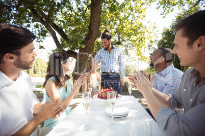 Group of friends celebrating womans birthday at outdoor restaurant