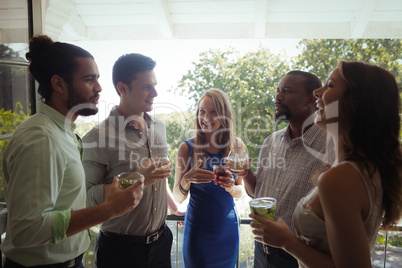 Group of friends interacting with each other while having cocktail drink