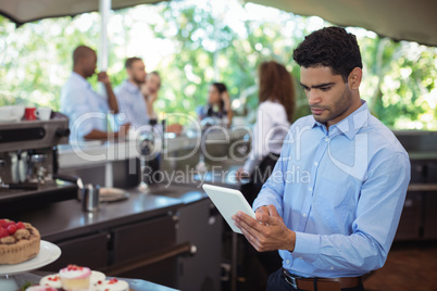 Waiter using digital tablet at outdoors cafe