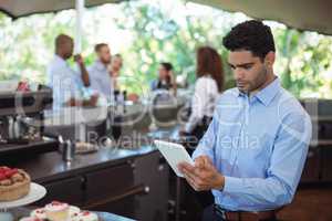 Waiter using digital tablet at outdoors cafe