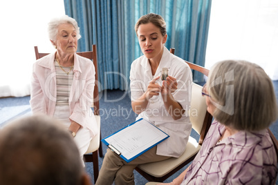 Female doctor explaining medicine to senior people