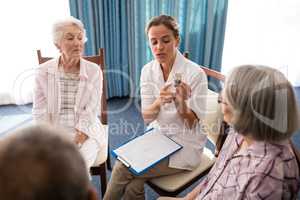 Female doctor explaining medicine to senior people
