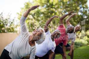 Senior people looking up while exercising with arms raised