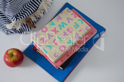 Books, apple and schoolbag on white background