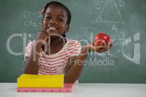 Schoolgirl holding a red apple against white background