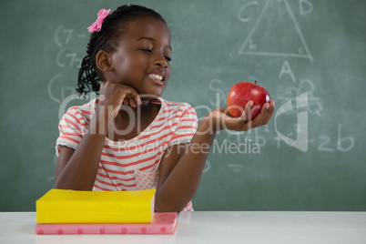 Schoolgirl holding a red apple against white background