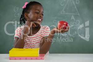 Schoolgirl holding a red apple against white background