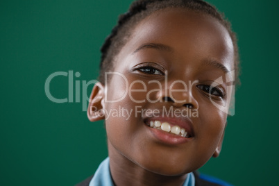 Smiling schoolgirl against green background