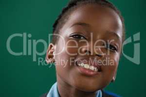 Smiling schoolgirl against green background