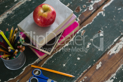 Apple on stack of books with various stationery