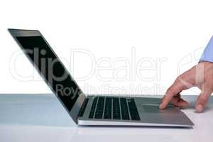 Cropped hand on businessman touching touch pad on laptop