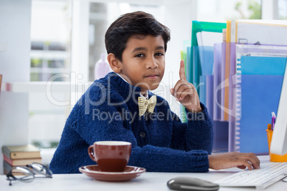 Portrait of businessman gesturing siting at desk