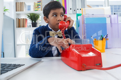 Businessman looking away while talking on land line phone