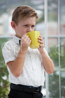 Thoughtful businessman looking away while holding yellow mug