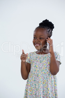 Smiling businesswoman pointing while talking on phone