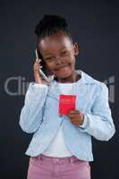 Portrait of smiling businesswoman talking on phone while holding red card