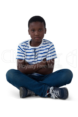 Portrait of sad boy sitting on floor