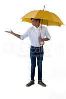 Boy standing under a yellow umbrella