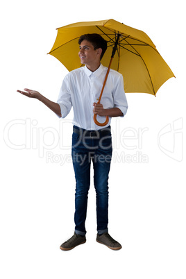 Boy standing under a yellow umbrella