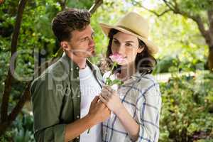 Couple smelling flower in garden