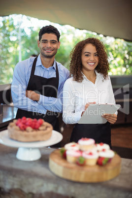 Male waiter and female waitress with clipboard